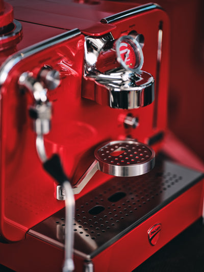 Angled detail of the red Barista M3 with pressure gauge, chrome brew head and steam wand