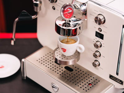 Espresso running into a white Ducati espresso cup on the drip tray of the white Barista M3