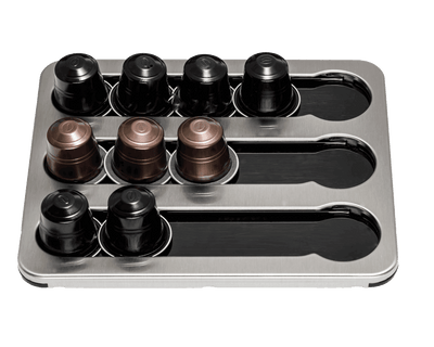 Silver capsule holder at an angle with nine black and copper capsules in its slots