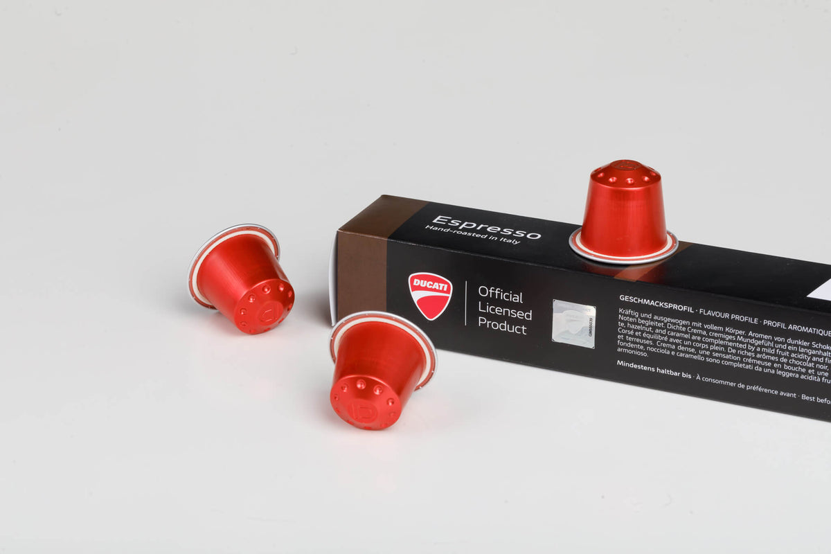 Primer plano de la caja Espresso by Ducati, Official Licensed Product, con cápsulas rojas compatibles con Nespresso® Original