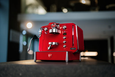 Red Barista M3 standing on a dark counter in a softly lit interior