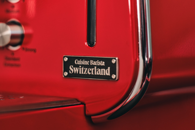 Cuisine Barista Switzerland nameplate on a red body panel beside the chrome edge trim